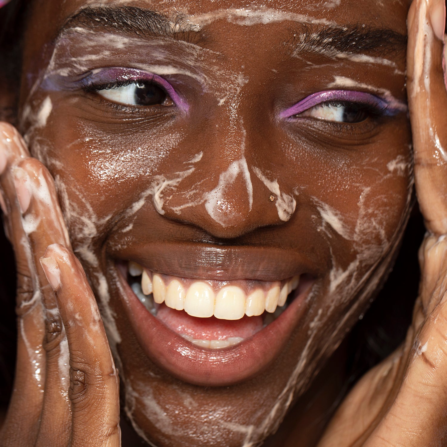 Woman cleansing her face with foamy Pink Cloud cleanser